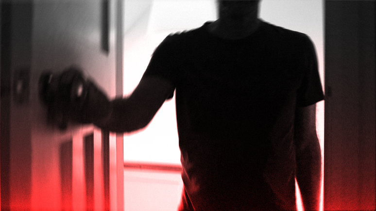 Silhueta de um homem abrindo uma porta na penumbra
